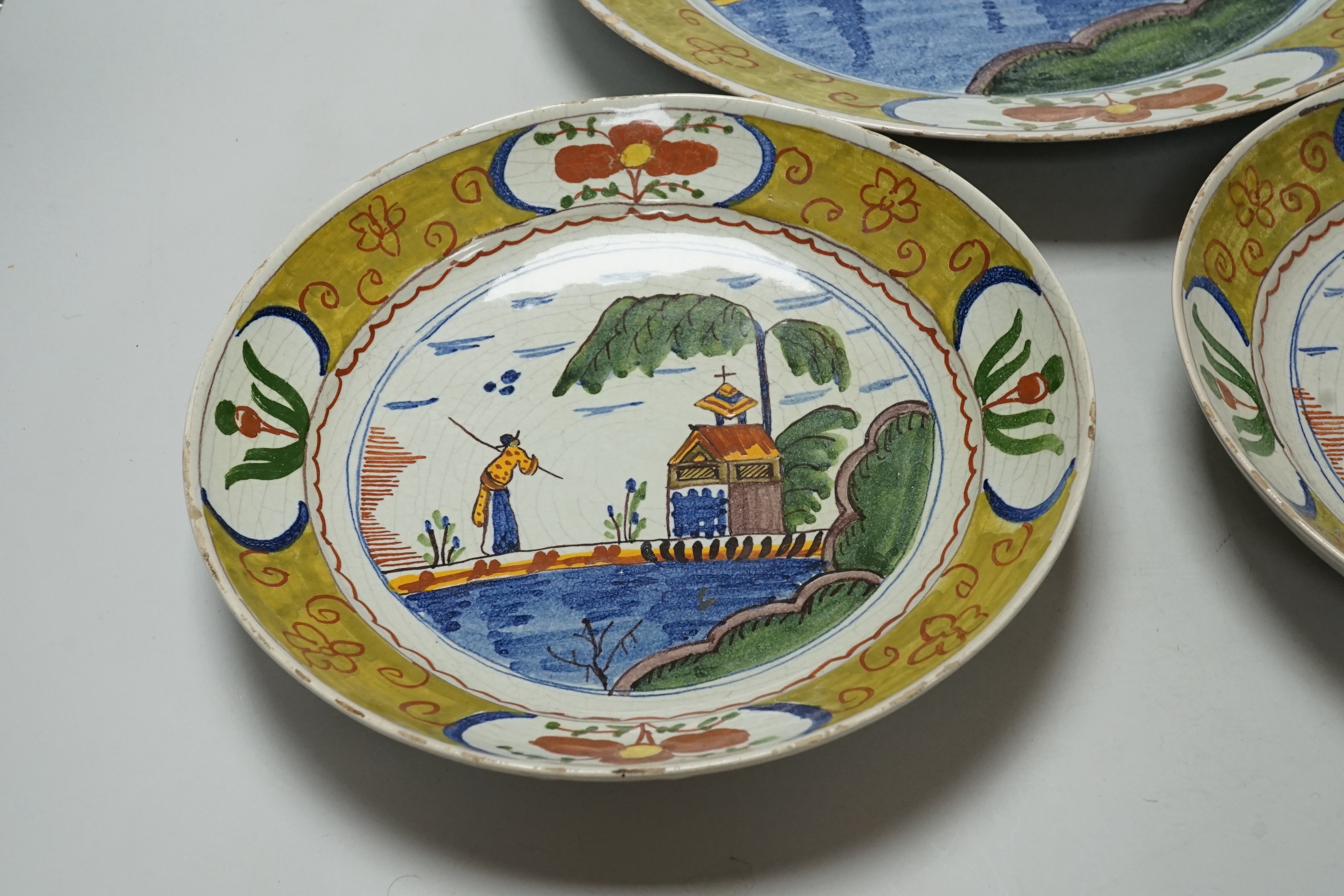 A Delft charger and a pair of similar dishes, largest 34cm diameter